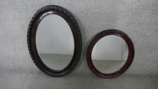 An early 20th century oval wall mirror with gadrooned frame and bevelled plate and another