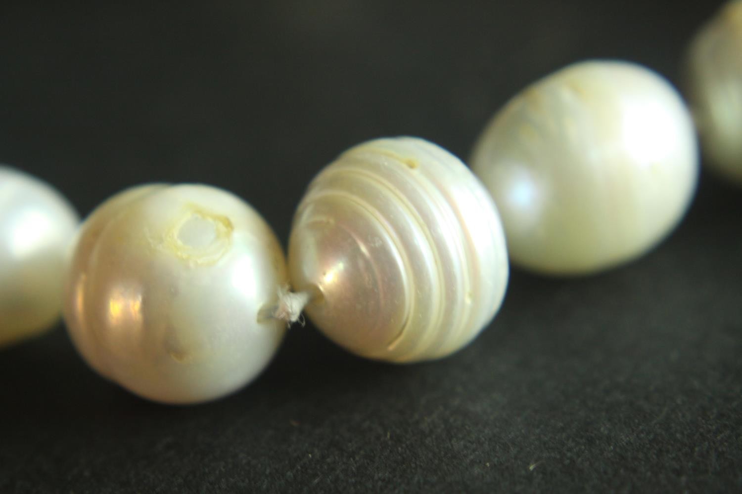 A string of vintage knotted baroque cultured pearls with a silver hook and push clasp. H.7 W.10 cm. - Image 5 of 6