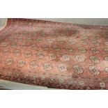 A Bokhara motif carpet with repeating gul medallions on a burgundy field. L.320 W.250cm.