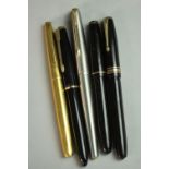 A collection of five gold-nibbed vintage fountain pens, including an 18 carat gold-nibbed
