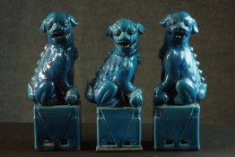 Three 20th century Chinese turquoise glaze Foo dogs on pedestal bases. H.26 W.9cm.