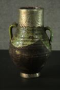 A large Eastern art pottery twin handled vase with silver plated engraved collar and base. H.32cm.
