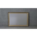 A contemporary gilded wall mirror with pomegranate and foliate design. H.62 W.86 cm