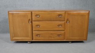 A vintage Ercol light elm sideboard, model 455, fitted with sliding cutlery drawer. H.68 W.155 D.