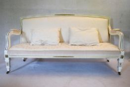 A late 19th Century painted and gilt settee in cream brocade upholstery on square tapering