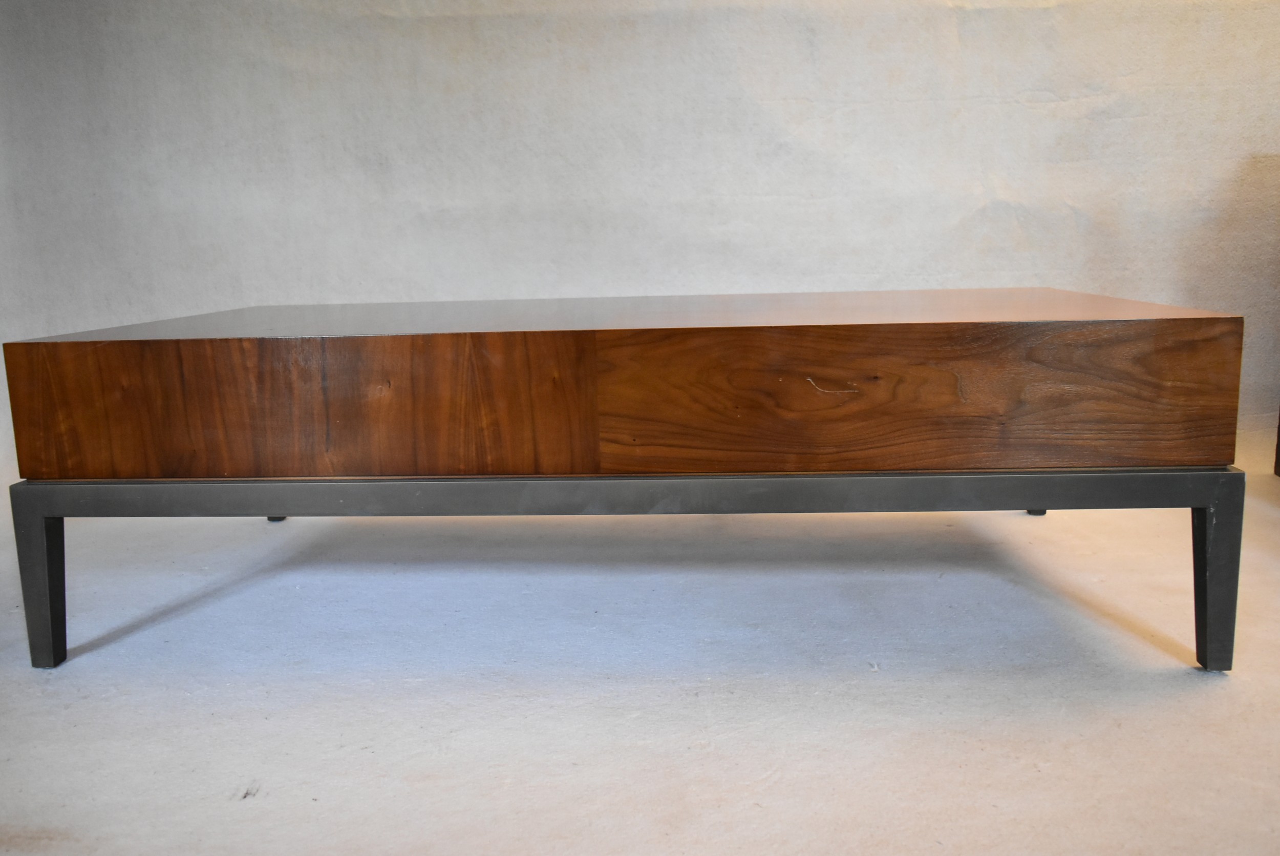 A contemporary teak coffee table fitted with end drawer on painted base with square tapering