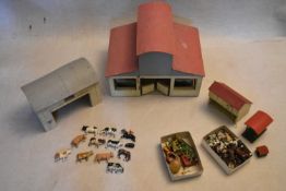 A group of vintage farmyard buildings along with a collection of lead figures, animals, farm