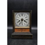 A 19th century French black painted mantel clock with enamel dial and Roman numerals, decorated with