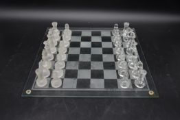 A contemporary glass chess set. To include thirty two pieces, 16 frosted glass pieces and 16 clear