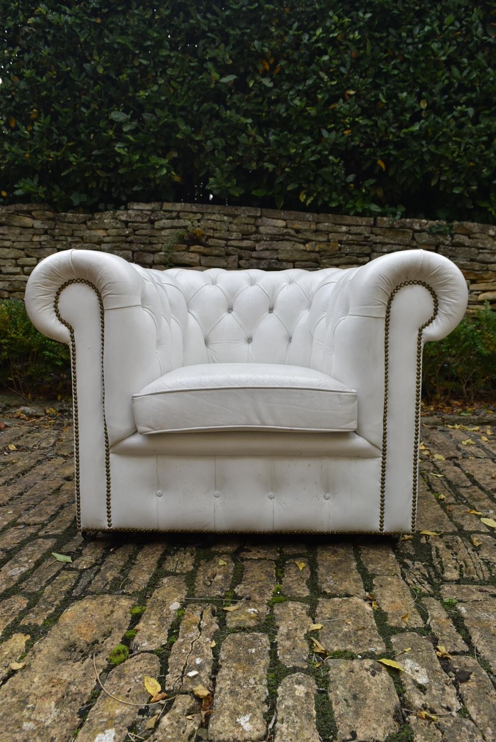 A Chesterfield armchair in deep buttoned and studded leather upholstery. H.70 W.103 D.80cm