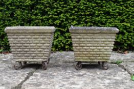 A pair of reconstituted garden planters on scrolling wrought metal bases. H.28 W.28 D.28cm