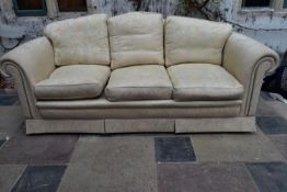 A three seater sofa in floral damask upholstery.