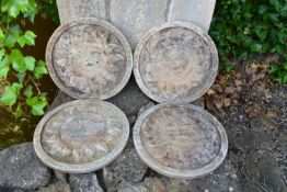 A set of four weathered reconstituted stone wall plaques with sunny faces. Dia.31cm