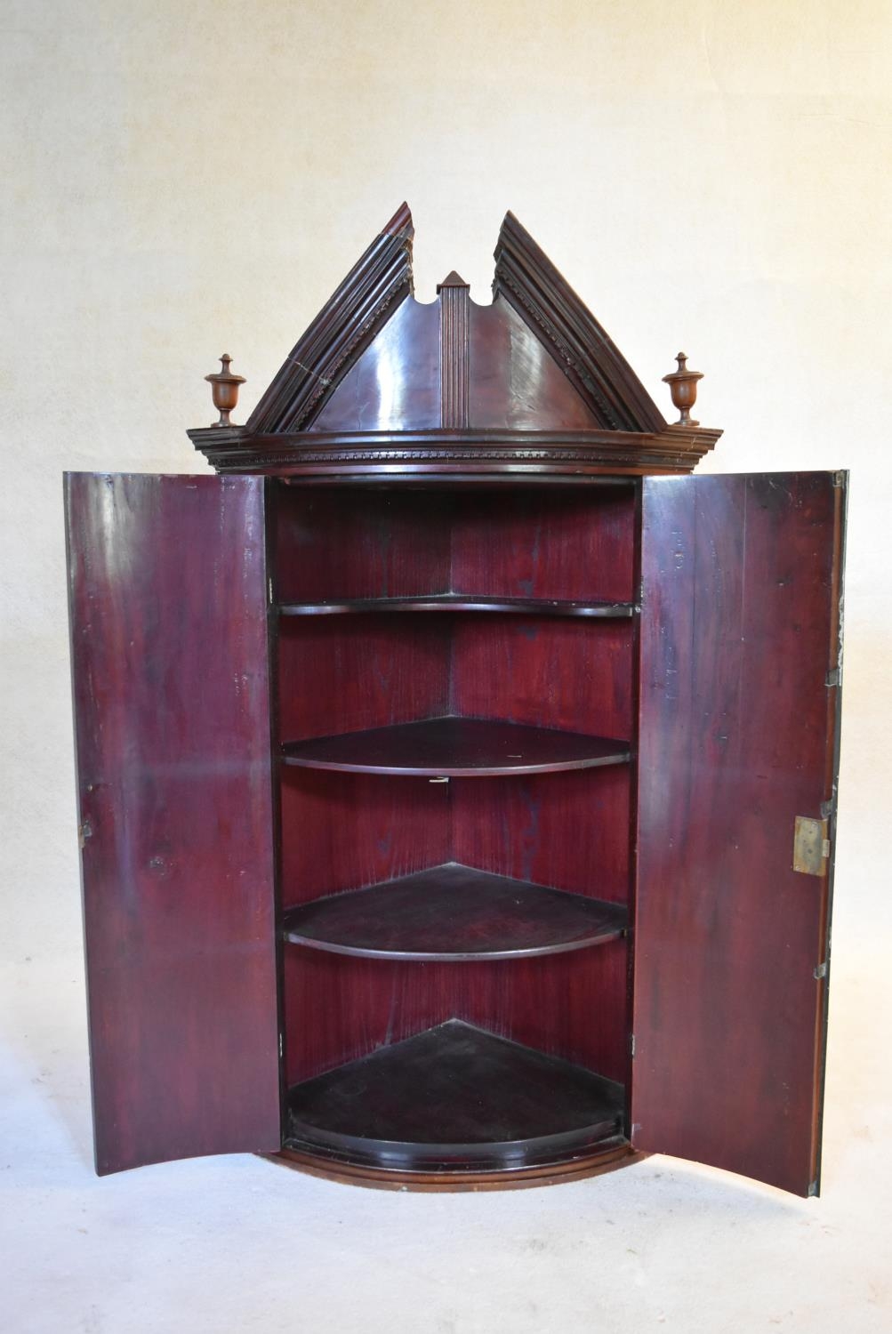 A Georgian mahogany bowfronted hanging corner cabinet with arched pediment and urn finials and - Image 2 of 10