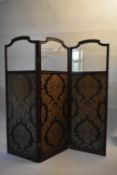 A 19th century mahogany framed two fold, three panel screen with shaped bevelled glass upper