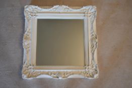 A bevelled wall mirror in painted Rococo frame. H.60 W.60cm