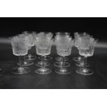 A set of twelve hand cut and machine engraved sherry glasses with foliate and cross hatched