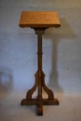 A Gothic style light oak lectern raised on chamfered and pegged pedestal resting on a platform base.