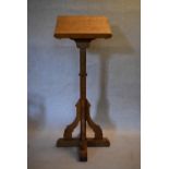 A Gothic style light oak lectern raised on chamfered and pegged pedestal resting on a platform base.