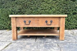 A contemporary pitch pine low table fitted with frieze drawers on block supports united by