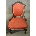 A late 19th century carved mahogany salon chair in geometric floral upholstery on tapering fluted