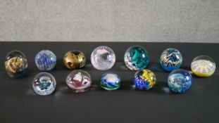 A collection of twelve limited edition lamp work paperweights by various makers, including