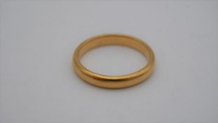 A 1920's 22 carat yellow gold D-shaped court wedding band. Hallmarked: London, 1925. Size N 1/2.