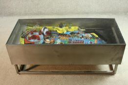 A contemporary metal framed coffee table with the major section of a vintage pinball table to the