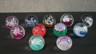 A collection of eleven limited edition Caithness lamp work glass paperweights. Stamped to the