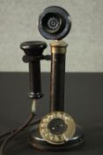 An early 20th century black bakelite and brass candlestick telephone. H.32cm.
