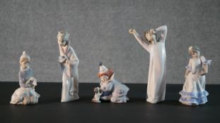 A collection of five Lladro porcelain figures, including a clown and puppy, girl with a lamb, boy in