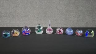 A collection of nine limited edition Caithness lamp work glass paperweights. Stamped to the base.