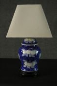 A Chinese style blue and white ceramic lidded urn vase converted into a table lamp. Decorated with