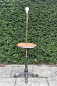 A vintage brass standard lamp with central tier on wrought iron lion's paw quadruped base. H.131 W.