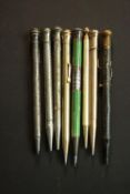 A collection of eight vintage and antique propelling pencils, including a day date silver and enamel