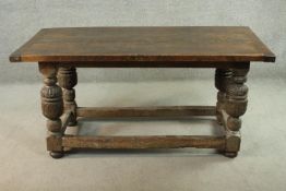 A late 16th century oak dining table, the three plank top with cleated ends on carved baluster
