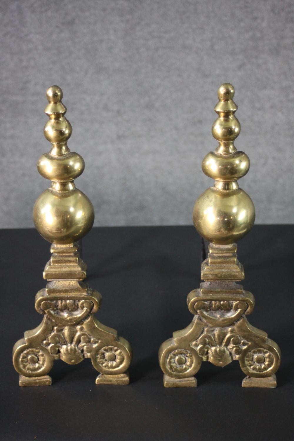 A pair of Victorian brass and cast iron fire dogs with floral motifs and turned finials. H.44 W. - Image 2 of 4