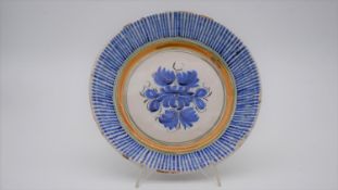 An Italian early 20th century glazed ceramic Deruta bowl with blue sunburst border and stylised