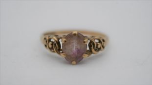 A 9ct yellow gold dress ring set with an oval mixed cut amethyst with an approximate carat weight of