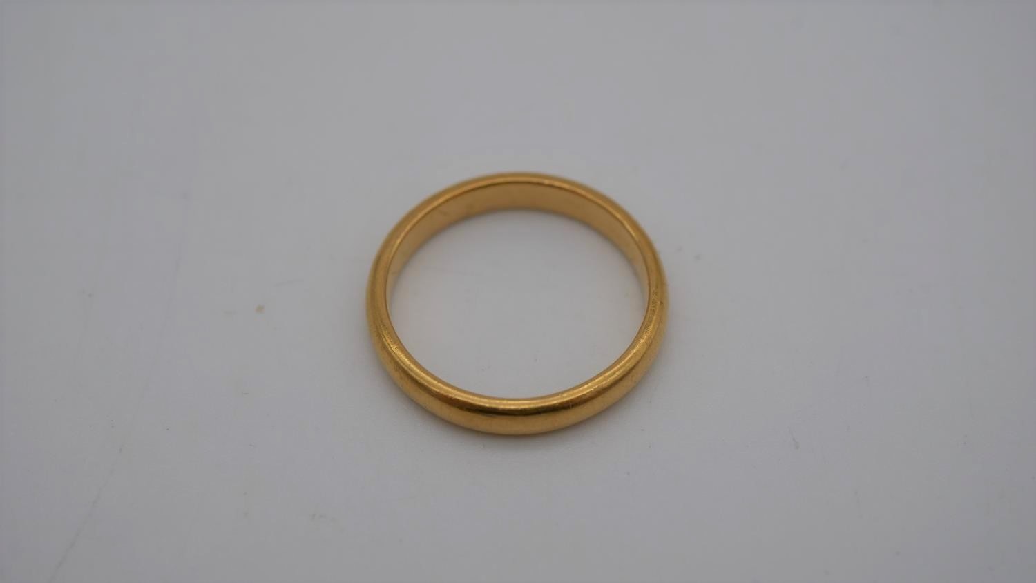 A 1920's 22 carat yellow gold D-shaped court wedding band. Hallmarked: London, 1925. Size N 1/2. - Image 2 of 6