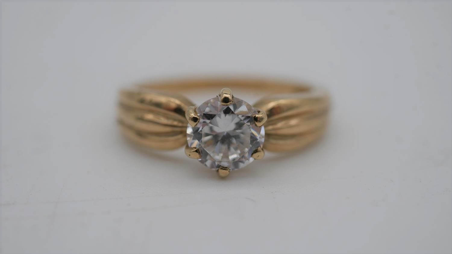 A cubic zirconia and 9 carat gold solitaire ring. Set to centre with a round brilliant cut cubic