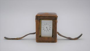 A fitted leather cased 19th century gilded brass French carriage clock, with bevelled plates and