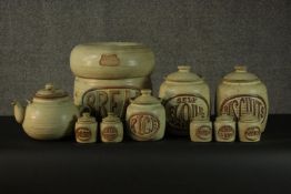 A collection of ten Tremar Cornish stoneware pots, bread jar and tea pot. Each with a different food