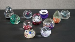 A collection of eleven lamp work paperweights by various makers, including CG, Mdina glass and