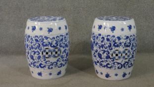 A pair of Chinese blue and white stools, of barrel form, painted with floral designs incorporating