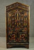 An Indian polychrome painted hardwood cupboard, with an arch top over two pairs of cupboard doors,