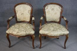 A pair of French Louis XV style stained beech fauteuils, with foliate upholstery, on cabriole legs.