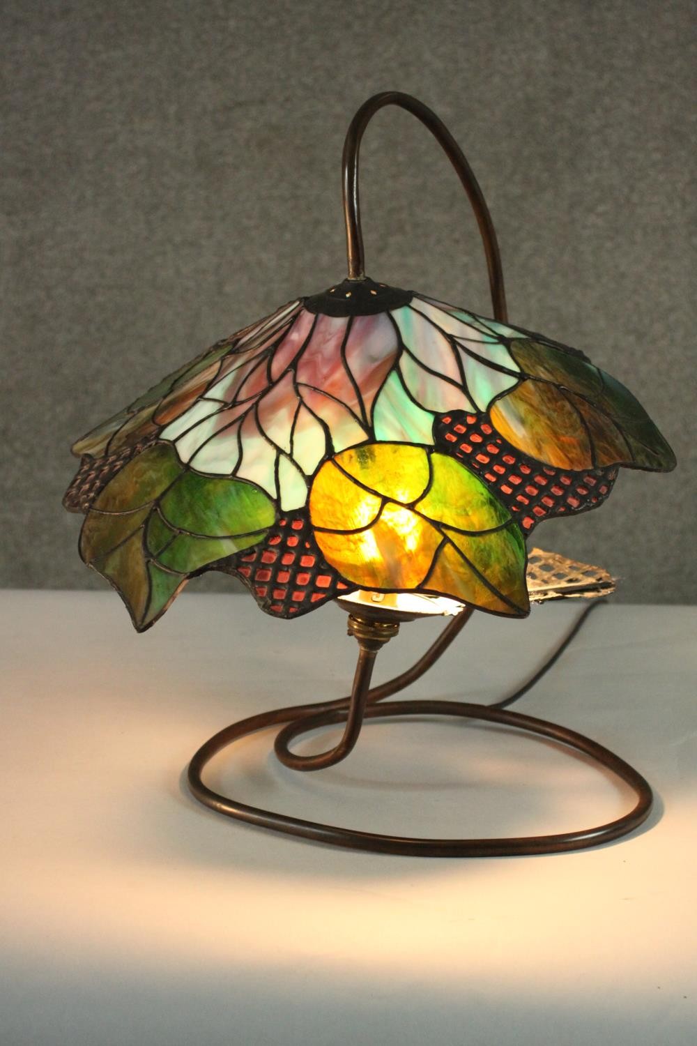 A Tiffany style stained glass table lamp, the shade with foliate design. H.48 W.40cm.