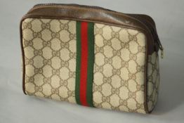 A vintage Gucci clutch bag in Beige PVC monogram with gold tone hardware and the iconic green and