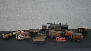 A collection of eleven tin plate locomotives, carriages and trams. Including NZR, LNWR. H.14 W.40